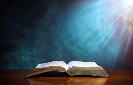Nyitott biblia fénysugarakkal, amelyek alapján ismerjük az Apostolok Tanát